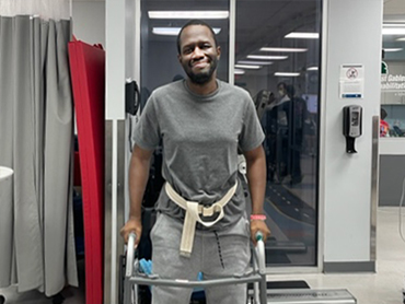 Thomas Hairston stands with a walker during therapy.